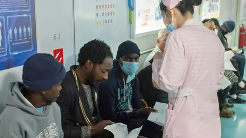 AFP A member of the Chinese military medical team assesses patients aboard the Peace Ark in Cape Town, South Africa - August 26, 2024